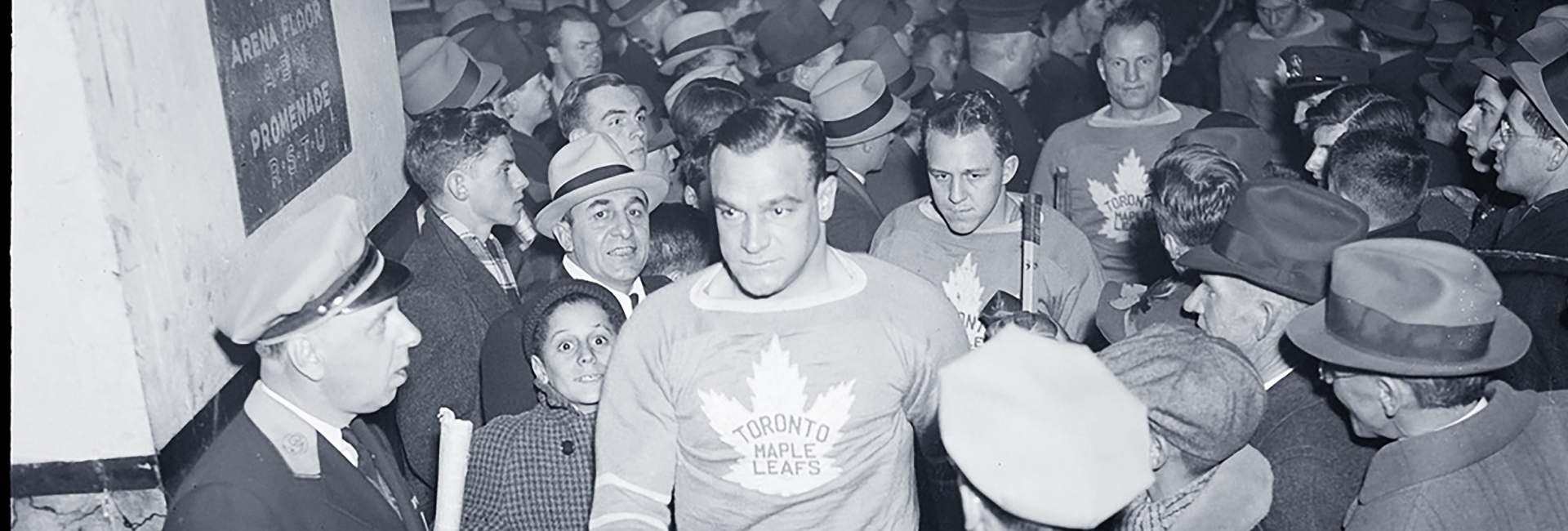 Hockey player from many years ago surrounded by fans