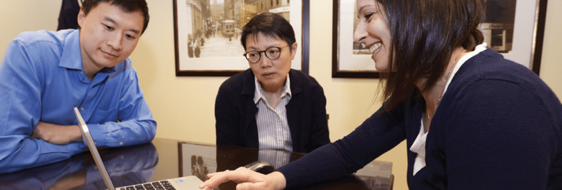 Funeral preplanner meeting with clients, reviewing arrangements on a laptop.