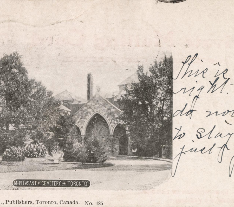 Alt text: Historic postcard photograph of Mount Pleasant Cemetery in Toronto showing the stone Gothic-style public vault partially framed by trees, with handwritten message text and a small British flag illustration on the right side.
