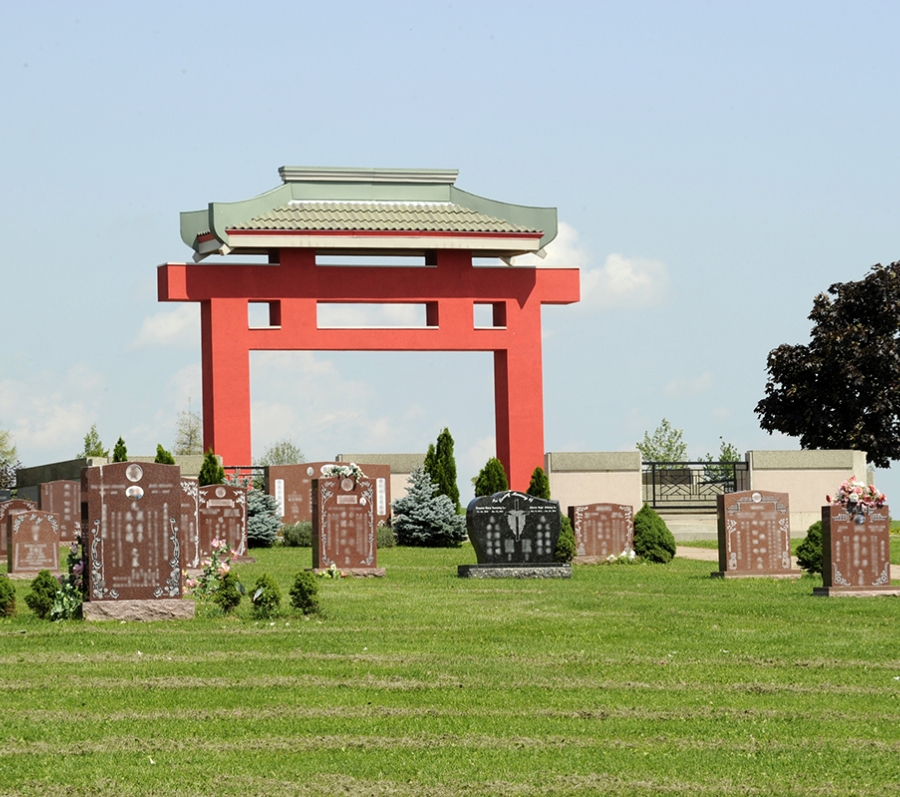 red chinese gate in the middle of a cemetery