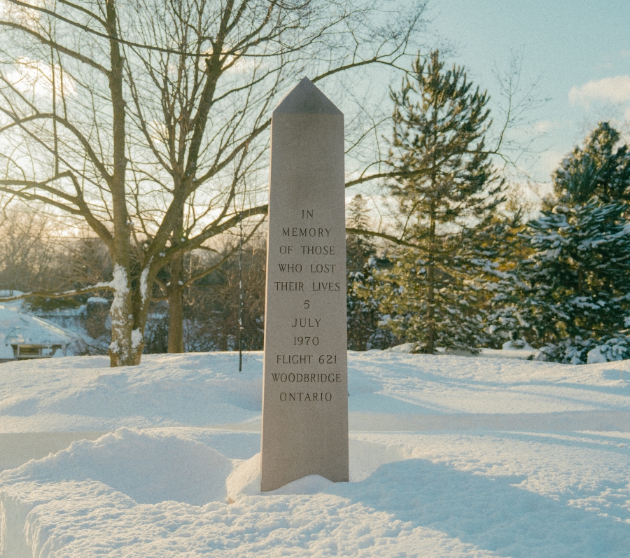 Stone memorial obelisk standing in a snow‑covered park, surrounded by trees in winter. An engraved inscription on the monument commemorates those who lost their lives on 5 July 1970 in Air Canada Flight 621 in Woodbridge, Ontario.