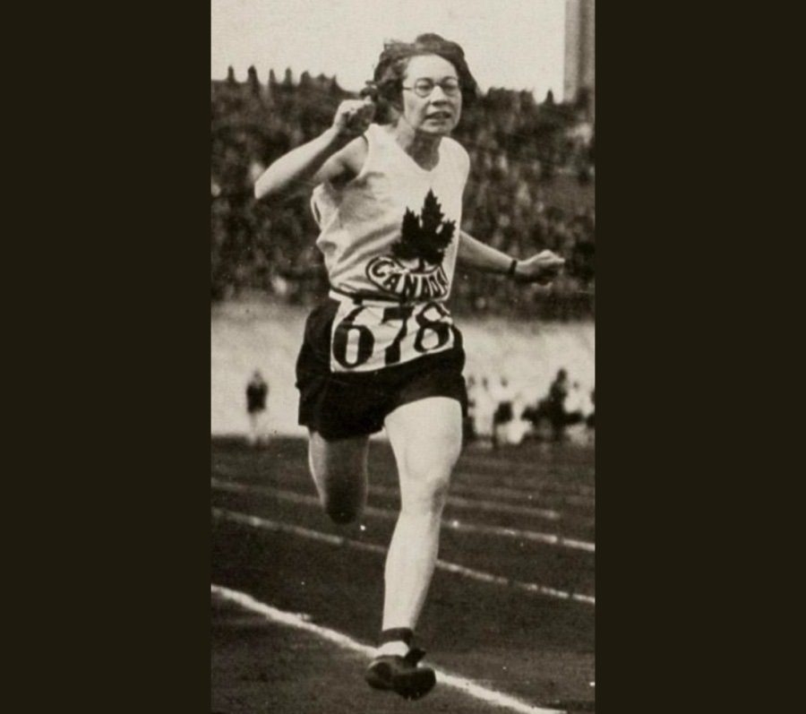 A runner wearing a sleeveless jersey with a maple leaf emblem and the word “Canada” sprints on a track, with one leg extended forward and arms pumping. The athlete’s bib number is 678, and a stadium crowd is visible in the background.