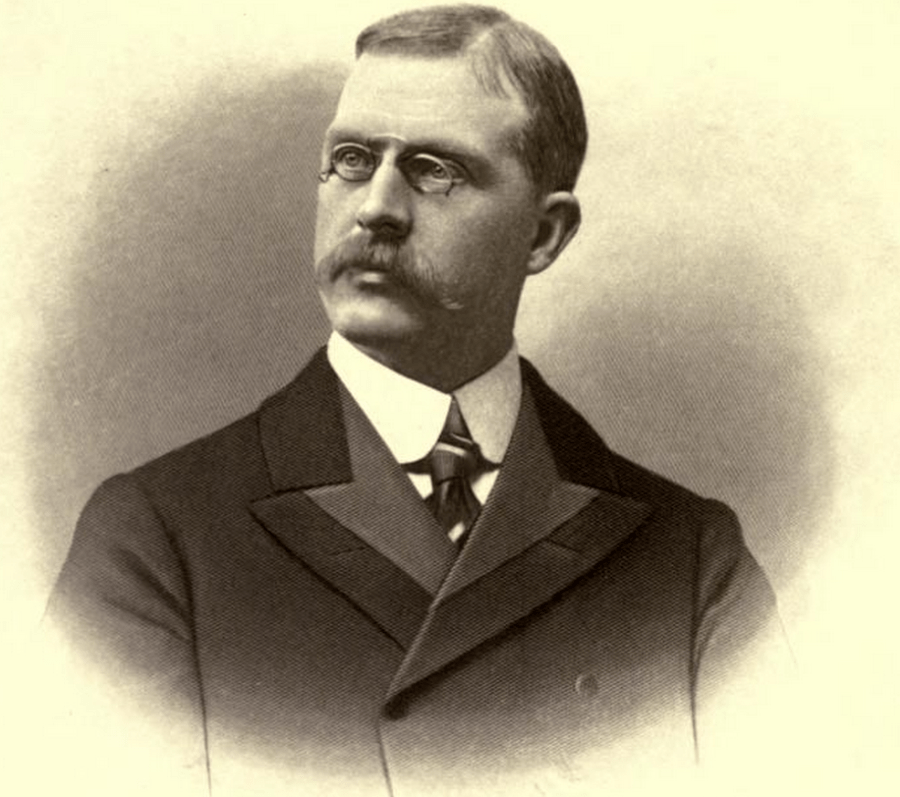 man in a suit with glasses in sepia