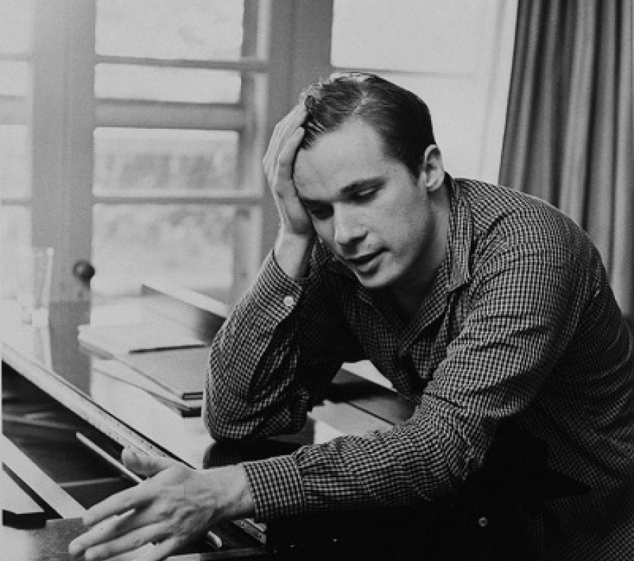 man at a piano with his head in his hands