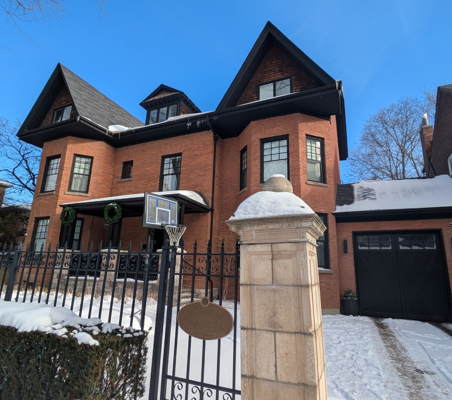 big brick house with a plaque on the gate