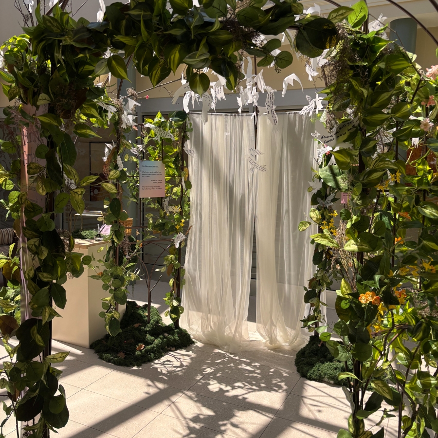 Leafy arch with hanging white bird cutouts and sheer curtains
