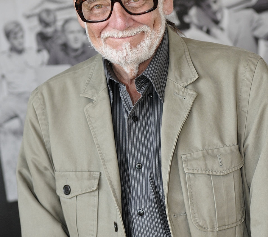 man with grey hair and a grey beard with black glasses
