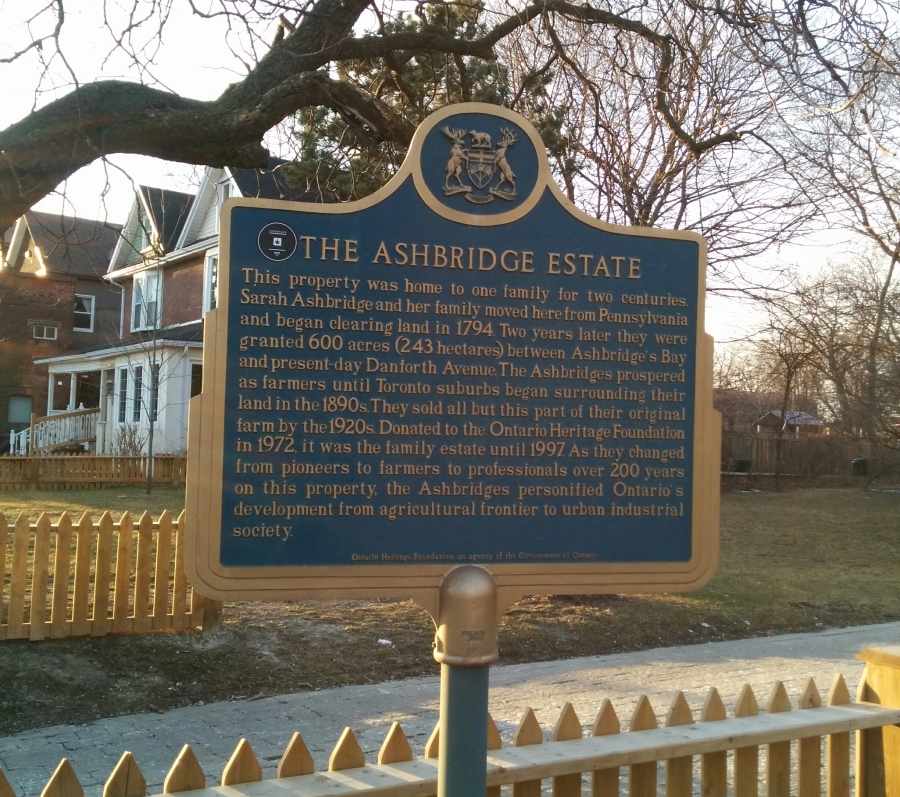 a plaque and white picket fence