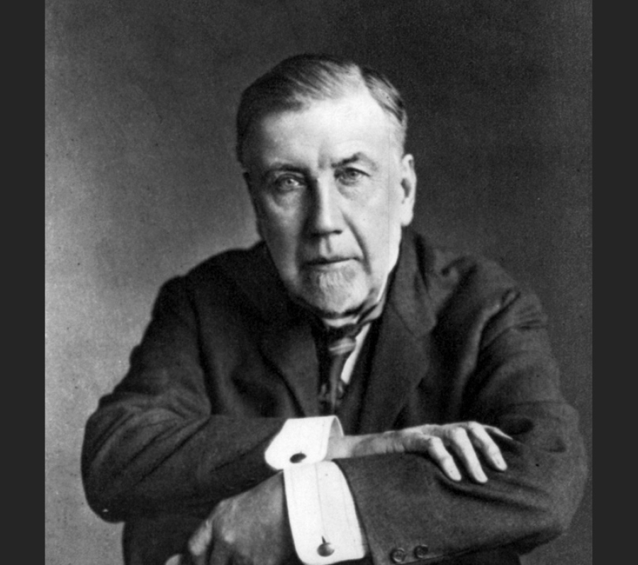 headshot of a man in a suit sitting in a chair