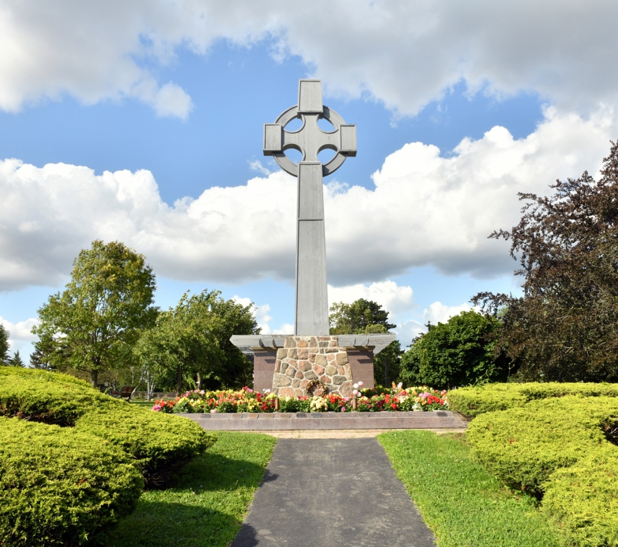 big cross surrounded by trees and grass
