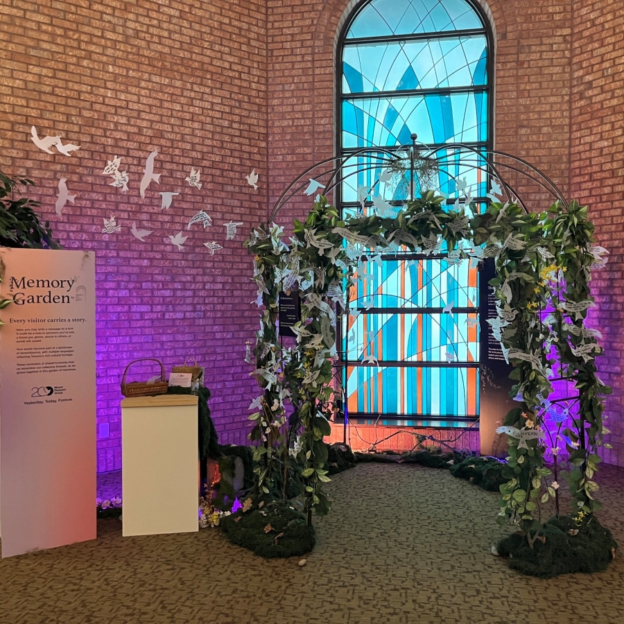 Memory Garden display with decorative arch, paper butterfly messages, and stained-glass window backdrop.