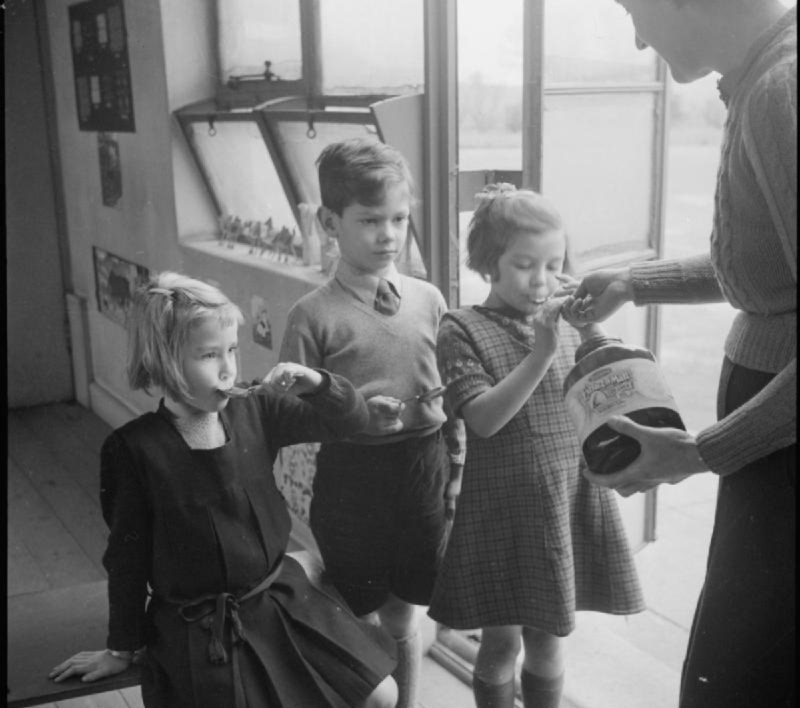 mother feeding her kids cod liver oil