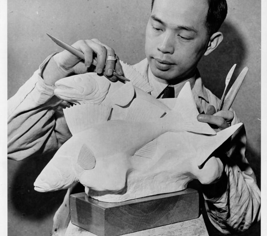 asian man with a paint brush sculpting