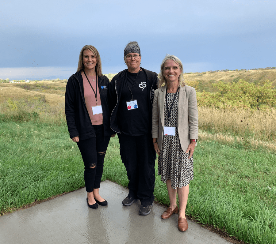 three people posing outside