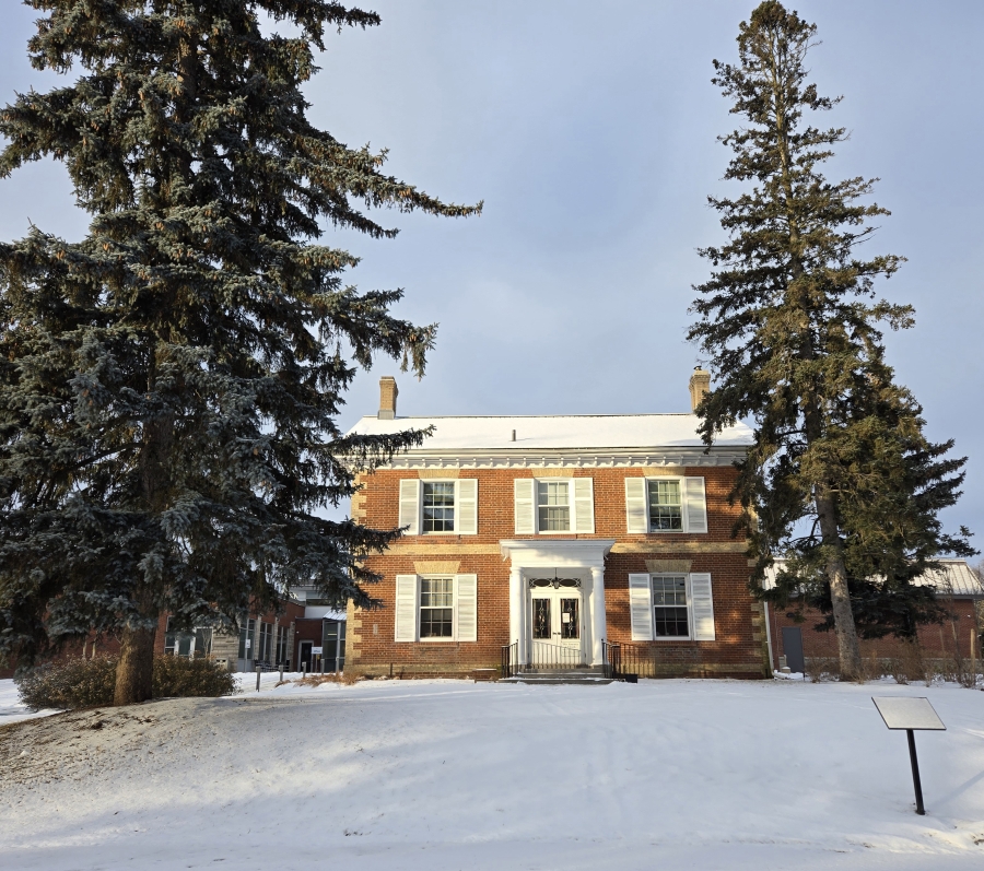 a house in the snow surrounded by trees