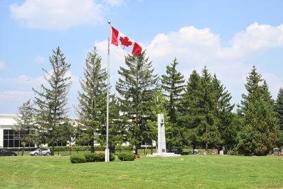 Canadian flag, pole, grass and trees at Elgin Mills