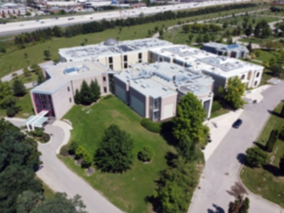 Aerial view of a large modern cemetery building surrounded by greenery.