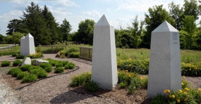 Stone memorial markers arranged in a landscaped garden setting.