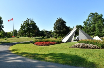 Modern granite memorial sculpture set in landscaped park grounds.