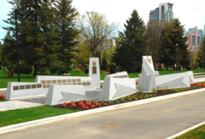 Contemporary memorial monuments with city skyline in the background.