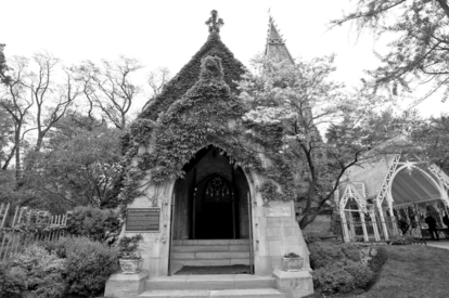 Gothic‑style cemetery chapel surrounded by trees and greenery.