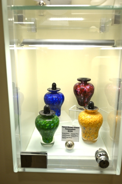 a colourful selection of urns behind a glass display