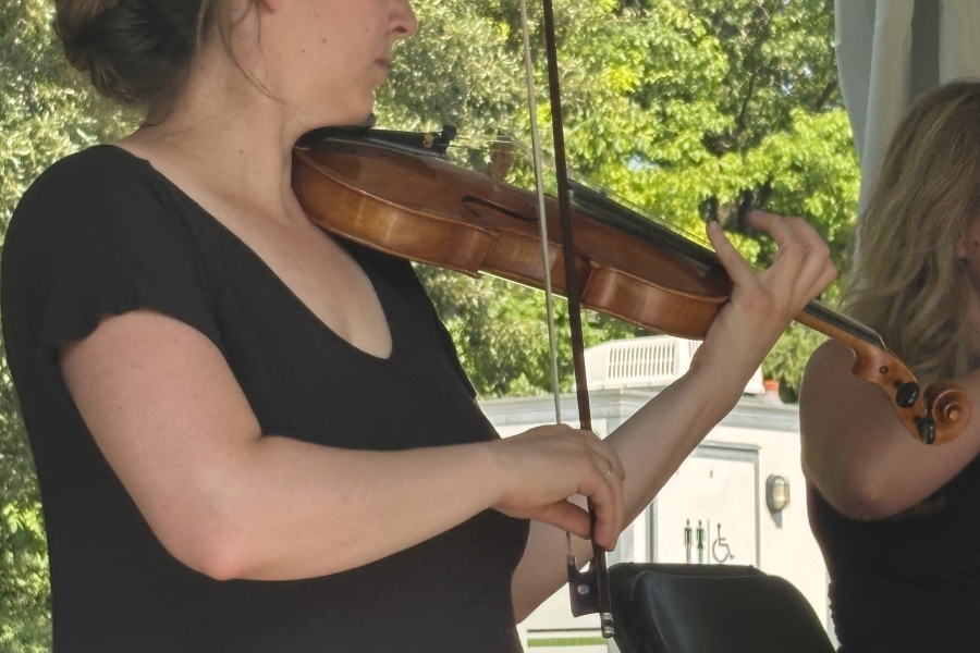 a woman in black playing the violin