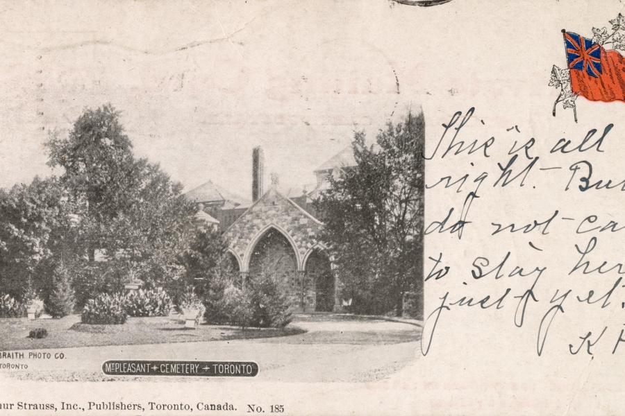 Alt text: Historic postcard photograph of Mount Pleasant Cemetery in Toronto showing the stone Gothic-style public vault partially framed by trees, with handwritten message text and a small British flag illustration on the right side.