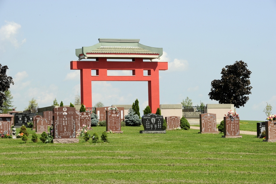 red chinese gate in the middle of a cemetery
