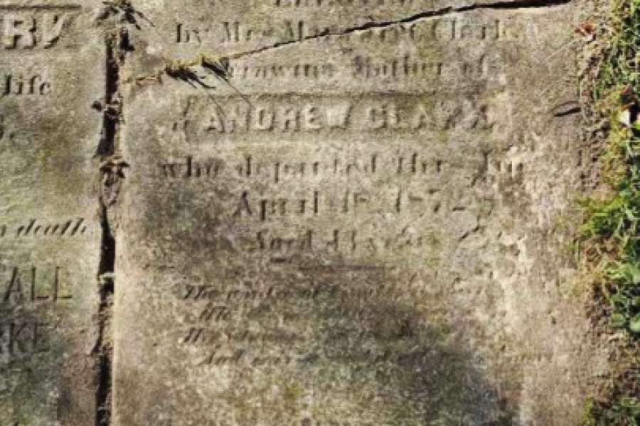 Weathered historic gravestone with faded inscription.