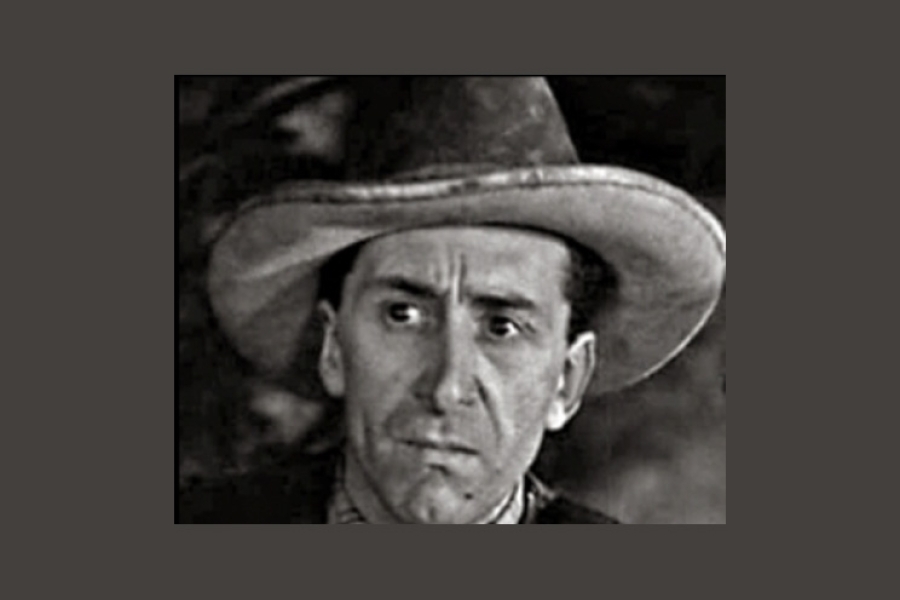 A person wearing a wide-brimmed cowboy hat, shown in a black‑and‑white photograph with a soft, out‑of‑focus background.