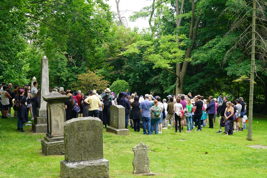 Participants on a guided history walk among old grave markers.