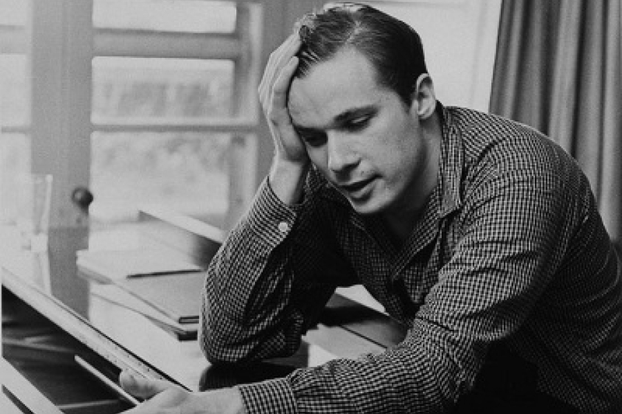 man at a piano with his head in his hands