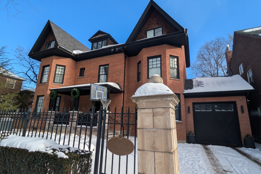 big brick house with a plaque on the gate
