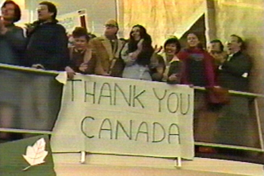 people holding up a big sign that says thank you canada