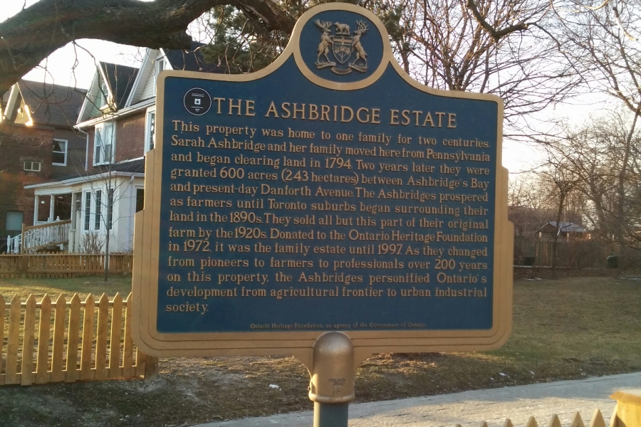 a plaque and white picket fence