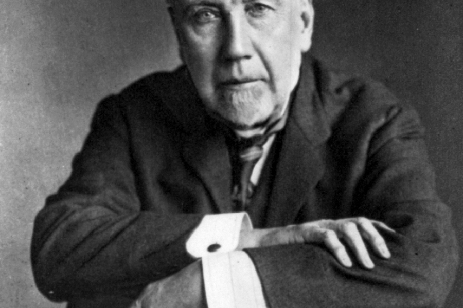 headshot of a man in a suit sitting in a chair