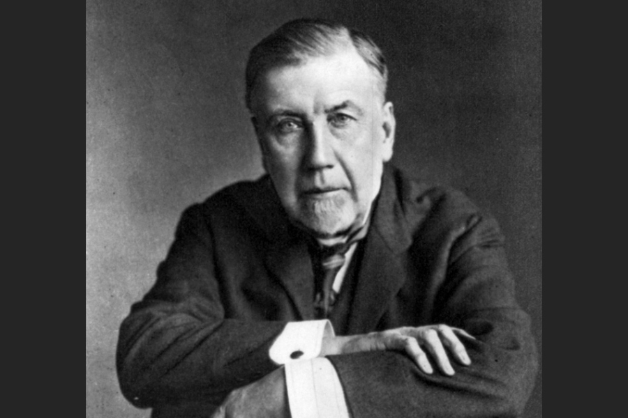 headshot of a man in a suit sitting in a chair