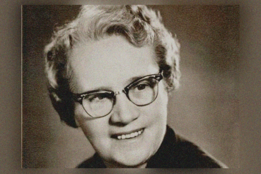 Colour portrait of a person shown from the shoulders up, with light, curly hair against a softly textured, warm‑toned background. The image has a grainy, archival appearance.