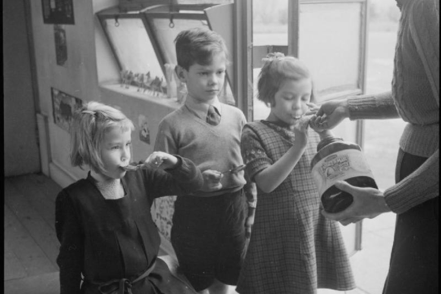 mother feeding her kids cod liver oil