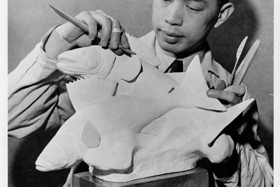 asian man with a paint brush sculpting