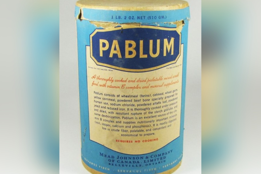 Vintage cylindrical tin of Pablum infant cereal with a blue label and gold lettering, showing detailed product information and nutritional claims, photographed against a plain background.