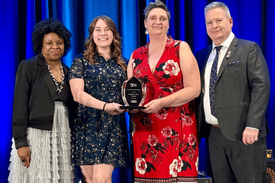 four people posing with an award