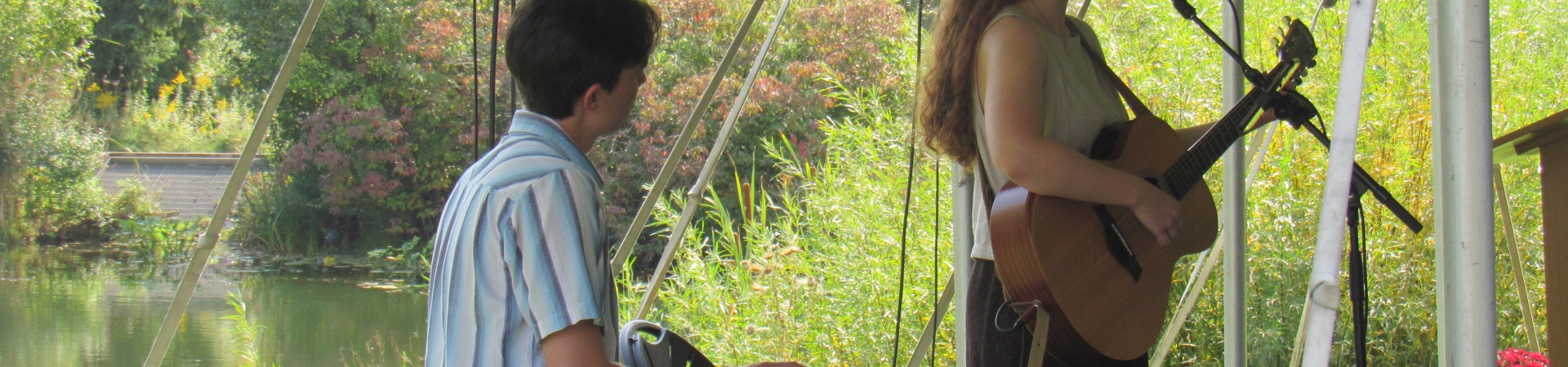 woman playing a guitar and a man playing a keyboard