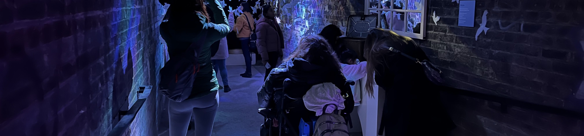 dark room with people wandering through an installation
